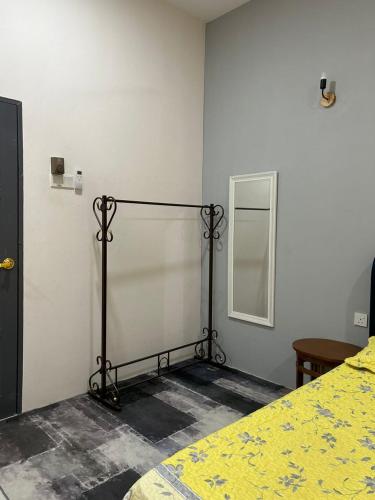 - une chambre avec un lit doté d'une couette jaune et d'un miroir dans l'établissement Aurora Roomstay, à Kota Bharu
