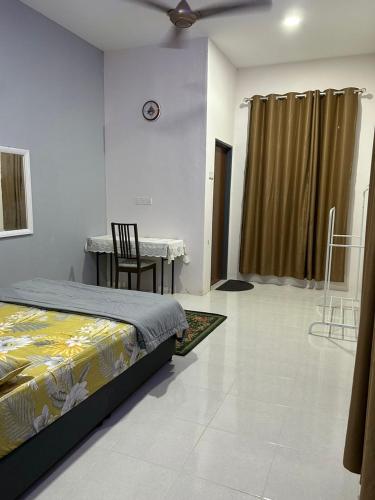 - une chambre avec un lit, une table et une chaise dans l'établissement Aurora Roomstay, à Kota Bharu
