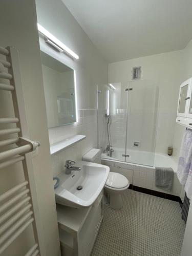 La salle de bains blanche est pourvue d'un lavabo et de toilettes. dans l'établissement Résidence Bois du Bouchet, appartement vue montagne, calme, parking gratuit, proche centre, à Chamonix-Mont-Blanc