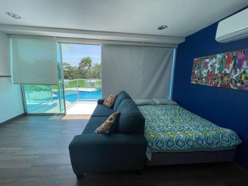 1 dormitorio con sofá y pared azul en Piscina Mar en el Paraíso Caribe, en Colón