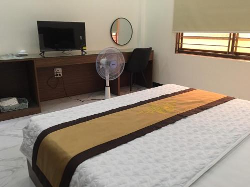 a bedroom with a bed with a fan and a tv at Phương Linh - Số 10 Cầu Đơ 3, Hà Đông - by Bay Hostel in Hà Ðông