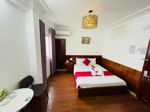 a hotel room with two beds and a table at PHÚ GIA BÙI VIỆN HOTEl in Ho Chi Minh City