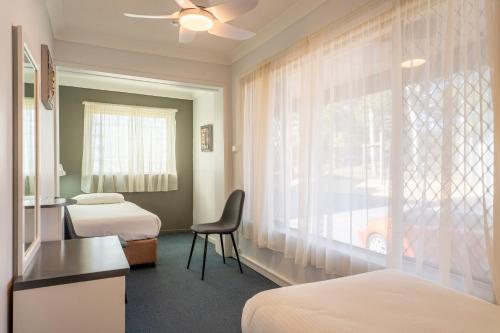 a hotel room with two beds and a window at Port Aloha Motel in Port Macquarie
