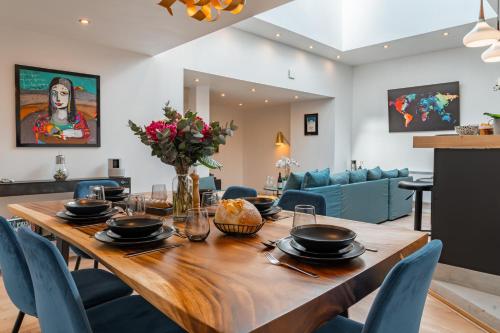 une salle à manger avec une table en bois et des chaises bleues dans l'établissement Maison Keryaute, à Sévrier
