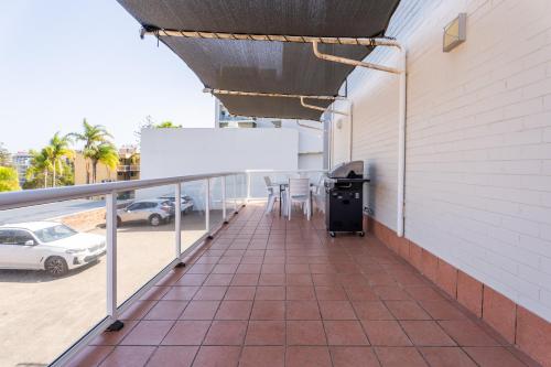 a balcony with a table and chairs in a parking lot at Port Aloha Motel in Port Macquarie