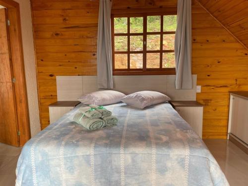 um quarto com uma cama com duas almofadas e uma janela em Pousada Recanto das Cachoeiras em Urubici