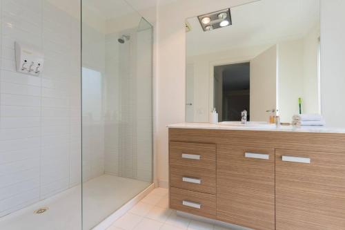 a bathroom with a shower and a sink and a mirror at Leafy Family Home with Outdoor Dining near CBD in Maribyrnong