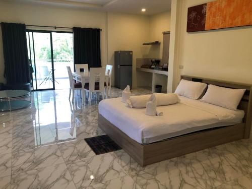 a bedroom with a large bed and a dining room at M&N Guesthouse Kata in Kata Beach