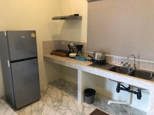 a kitchen with a stainless steel refrigerator and a sink at M&N Guesthouse Kata in Kata Beach