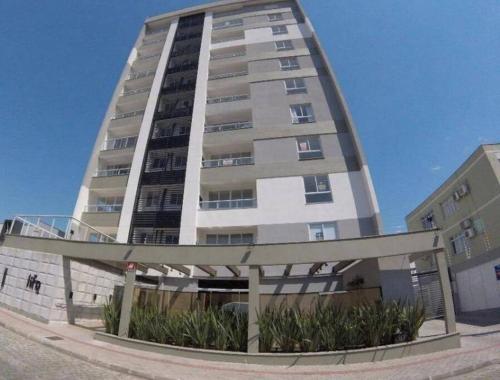 a tall apartment building with a gazebo in front of it at Loft proximo a Villa Germânica in Blumenau