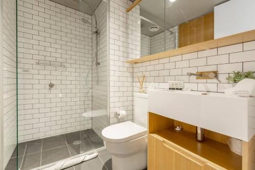 een witte badkamer met een toilet en een wastafel bij Flagstaff Chic - A Refreshing Balcony Retreat in Melbourne
