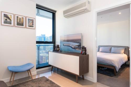 Schlafzimmer mit einem Bett, einem Schreibtisch und einem Fenster in der Unterkunft Elevated Elegance in the City's Chic Paris End in Melbourne