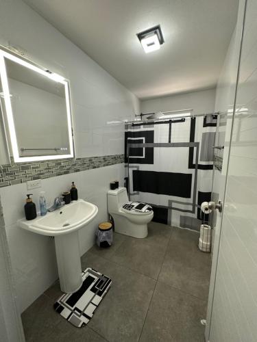 bagno con lavandino, servizi igienici e specchio di Black Pearl a Guayama