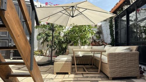 a patio with a table and an umbrella at CASA MARA Casa Rural con terraza, barbacoa y vistas al Teide in Tanque
