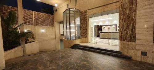 a lobby with a large window and a potted plant at الجوهرة البيضاء للشقق المخدومة in Jeddah