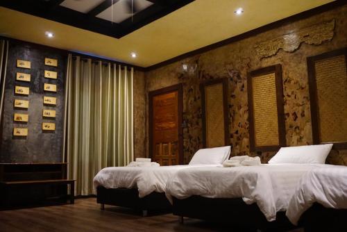 1 dormitorio con 2 camas con sábanas blancas en Seed Villa·Nimman Thai Local Lanna garden villa, en Chiang Mai