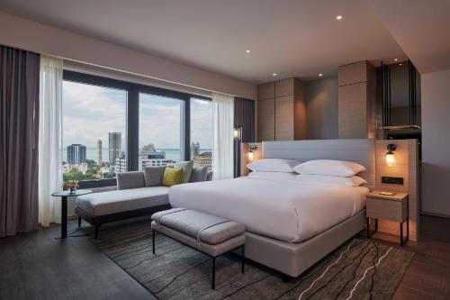 een slaapkamer met een groot bed en een groot raam bij Courtyard by Marriott Penang in George Town