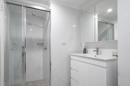 シドニーにある'Zen Boutique' A Well-connected Studio with Parkingのシャワーと洗面台を備えた白いバスルーム