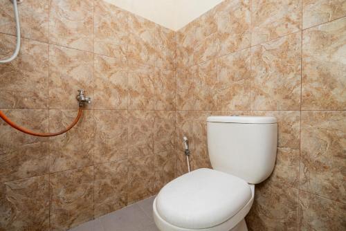 a bathroom with a toilet and a shower at RedDoorz Syariah At Danau Maninjau Sawojajar in Malang