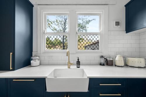 a kitchen with a white sink and a window at Pocket of Petersham - A Stylish Inner-West Retreat in Sydney