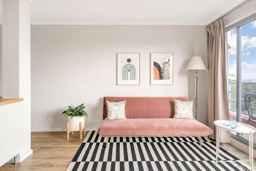 a living room with a pink couch and a window at 'Georgina' Mid-Century Modern Poolside Stay in Sydney