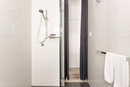 a bathroom with a shower with a glass door at A Cosy Scandi-Style Studio on Bondi Beach in Sydney