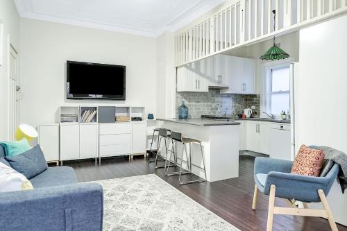 een keuken en een woonkamer met een bank en een televisie bij Coogee Classic - Coastal Gem Close to Beach in Sydney