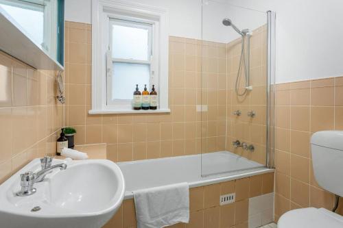 悉尼Eclectic Heritage Comfort with Terrace and Views的带浴缸、水槽和淋浴的浴室