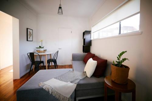 een woonkamer met een bank en een tafel bij Easy Esperanza - Compact Indoor-outdoor Living in Sydney