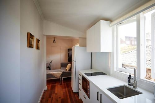 een keuken met een witte koelkast en een raam bij Easy Esperanza - Compact Indoor-outdoor Living in Sydney