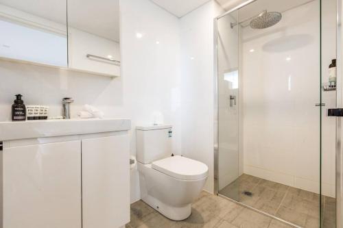 y baño blanco con aseo y ducha. en Bondi Beachfront Lifestyle - Ocean Views and Parking en Sídney