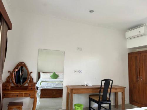 a bedroom with a bed and a mirror and a chair at Pererenan nengah guest house in Canggu