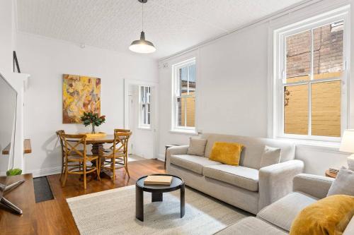 a living room with a couch and a table at Harbourfront meets Heritage Chic near Barangaroo in Sydney