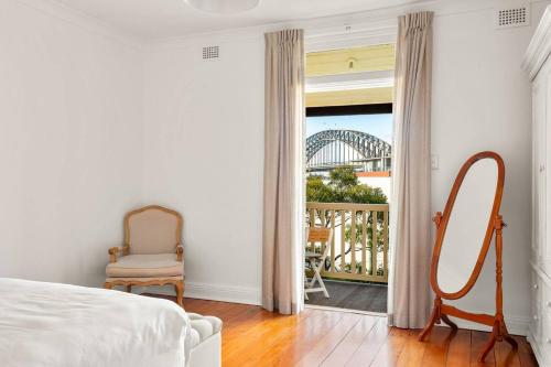 a bedroom with a bed and a mirror and a window at 'Two of a Kind' Heritage Stay with Harbour Views in Sydney