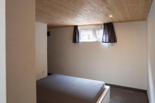a small bedroom with a bed and a window at Het Denneke in Veldhoven