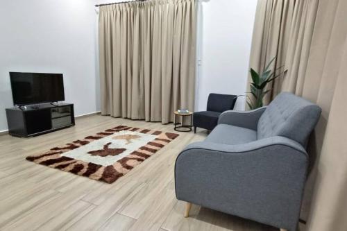 a living room with a couch and a tv at Tokiku Homestay Paka unit B in Paka