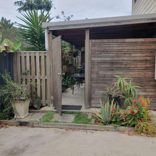 a wooden entrance to a garden with a wooden fence at Guesthouse in pacific paradise in Pacific Paradise 