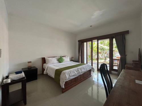 a bedroom with a bed and a sliding glass door at Pererenan nengah guest house in Canggu