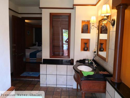 a bathroom with a sink and a mirror and a bed at Alpine LXPD Premium Water Chalet in Port Dickson