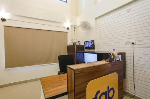 an office with a desk with a computer and a television at FabHotel Elite Homes in Nagpur