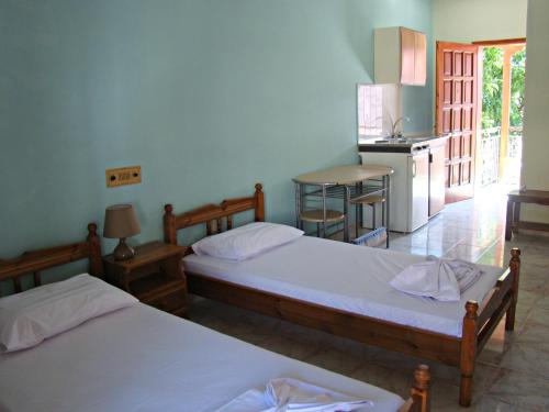 two beds in a room with a kitchen at Kristi in Póros Kefalonias