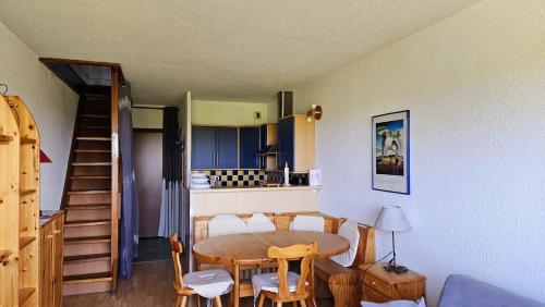 - une cuisine et une salle à manger avec une table et des chaises dans l'établissement Appartement Les rousses, Jura, aux Rousses