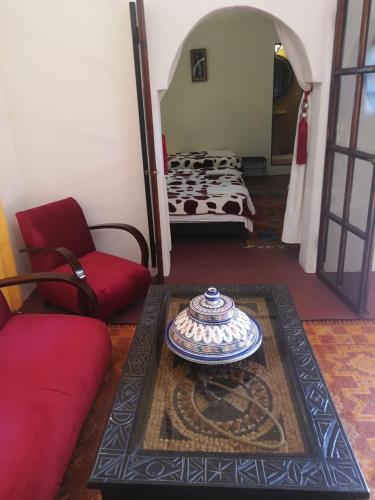 a living room with a bed and a table in a room at Chez Kossai Atlas Farm in Chtawna
