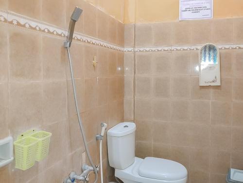 uma casa de banho com um WC e um chuveiro em RedDoorz at Rita Guesthouse Pangandaran em Pangandaran