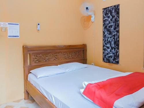 a bedroom with a bed and a window at RedDoorz at Rita Guesthouse Pangandaran in Pangandaran