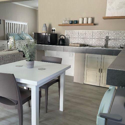 una cucina con tavolo e sedie bianchi in una stanza di Lavender Grove a George