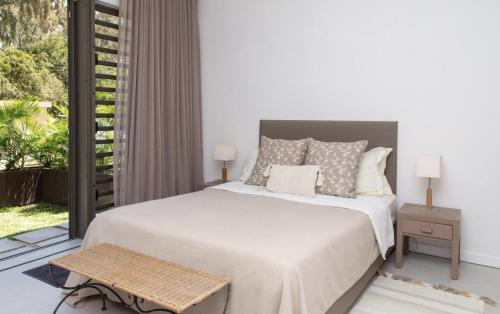 1 dormitorio con cama y ventana grande en Beach Villa Mauritius, en Roches Noires