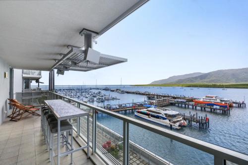 a balcony with a marina with boats in the water at Belle Escapes 24 Harbour Lights Water View Apartment in Cairns