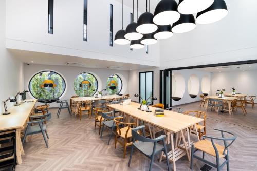 a dining room with tables and chairs and windows at Blu Monkey Hub and Hotel Krabi Town in Krabi town