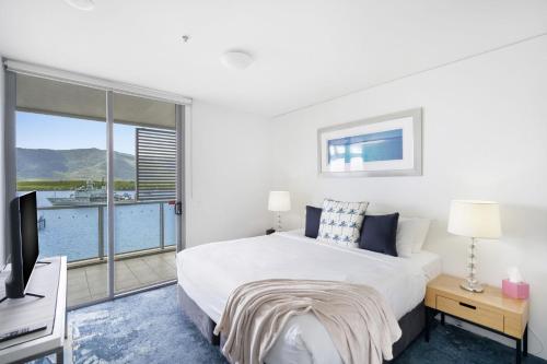 - une chambre avec un lit, une télévision et un balcon dans l'établissement Belle Escapes 24 Harbour Lights Water View Apartment, à Cairns